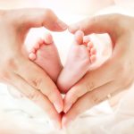 love and childhood - newborn feet in mom hands